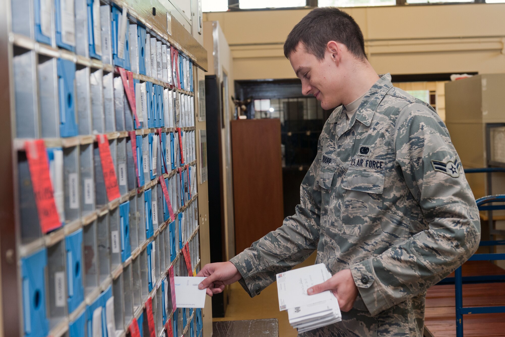 RAF ALCONBURY, United Kingdom – Airman 1st Class Trenton Ruopp, 423rd Communications Squadron RAF Alconbury postal clerk, places mail in customer’s boxes May 31. It currently takes Ruopp almost two hours to sort the almost 1,700 daily letters the RAF Alconbury Post Office receives before he can place it in customers’ boxes. When the post office starts using the Optical Character Reader to read the zip Plus 4, mail will already be sorted when it arrives at the post office and customers will be able to receive their mail quicker. (U.S. Air Force photo by Staff Sgt. Brian Stives)