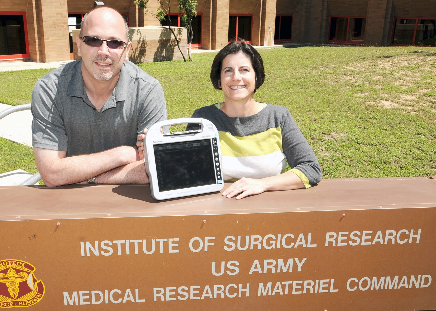 (From left) Jose Salinas, Ph.D., U.S. Army Institute of Surgical Research research task area program manager for comprehensive intensive care research, and Maria Serio-Melvin, USAISR clinical program coordinator for computer decision support systems and co-chair of the integrated product team that is fielding the Burn Navigator, display the device, which recently received 510(k) clearance from the U.S. Food and Drug Administration. (Photo by Steven Galvan, U.S. Army Institute of  Surgical Research Public Affairs)