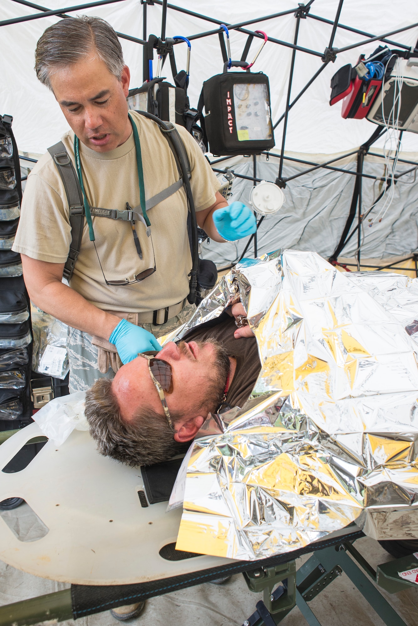 U.S. Air Force Lt. Col. Charles Drown, left, medical element commander with the 165th Medical Group, Georgia Air National Guard, speaks with a simulated patient after covering him with an aluminum warming blanket during the Vigilant Guard 2013 exercise at Camp Blanding, Fla., May 21, 2013.  The Medical Groups from the 116th Air Control Wing and the 165th Airlift Wing are a key component of the 78th Homeland Response Force set up to respond to disasters in the Southeast U.S. region.  During the exercise, Guardsmen responded to various scenarios such as a plane crash, train derailment, hurricane, and an explosion at a chemical plant. (U.S. Air National Guard photo by Master Sgt. Roger Parsons/Released)