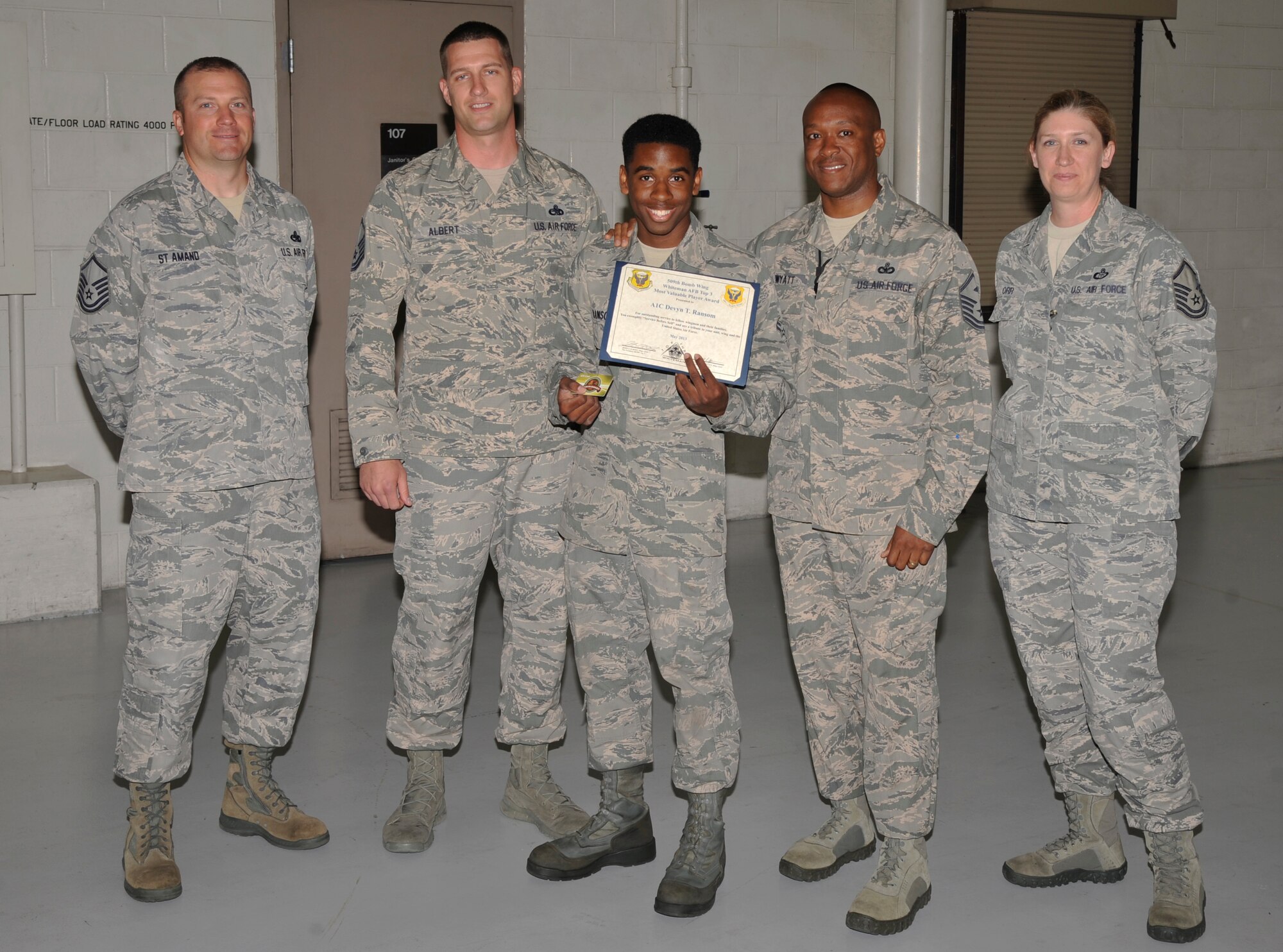 Airman 1st Class Devyn Ransom, 509th Maintenance Squadron aerospace ground equipment journeyman, receives the Top III MVP award for May on Whiteman Air Force Base, Mo., May 23, 2013. Ransom dispatched more than 500 assets during the two-week-long B-2 Spirit exercise and completed his annual quality assurance evaluation with a 100-percent pass rate. He also assisted with a clean-up detail in Knob Noster State Park and is involved with the dorm council. (U.S. Air Force photo by Airman 1st Class Berry/Released)