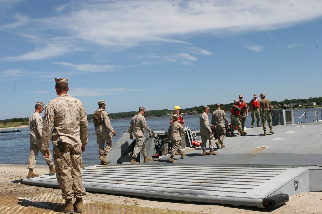Service members from II Marine Expeditionary Force board a navy lighterage vessel during a Marine Prepositioning Force exercise conducted aboard Marine Corps Support Facility Blount Island, Fla., May 25, 2013. Sailors from Beach Master Unit Two showed the II MEF service members various areas of the vessel and how it worked. (U.S. Marine Corps photo by Lance Cpl. Shawn Valosin)