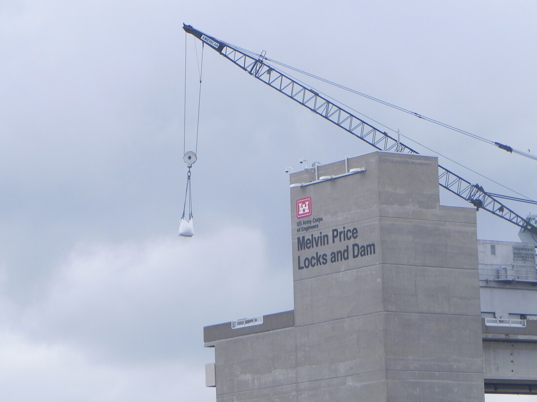 A crane at the Melvin Price Locks and Dam in Alton, Ill., lifts a large bag filled with sand onto a barge on the Mississippi River, June 2, 2013.