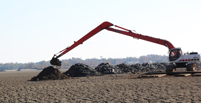 A backhoe digs a ditch in Clouter Creek to drain excess water.