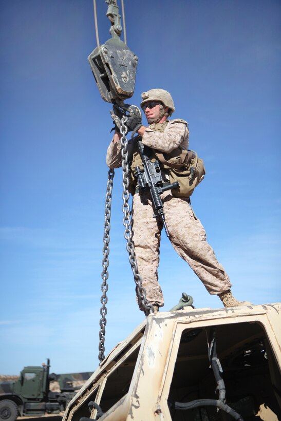 Marine Corps Cpl. Timothy J. Leicht hooks a chain during a vehicle recovery training exercise on Twentynine Palms, Calif., May 25, 2013. Leicht, a wrecker operator, is assigned to Combat Logistics Battalion 6, 2nd Marine Logistics Group.