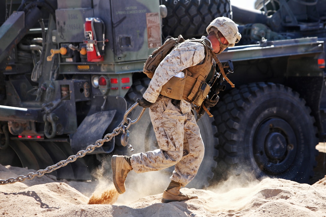 A Marine drags a chain past a wrecker truck during a vehicle recovery training exercise on Twentynine Palms, Calif., May 25, 2013. The Marine is assigned to Combat Logistics Battalion 6, 2nd Marine Logistics Group.