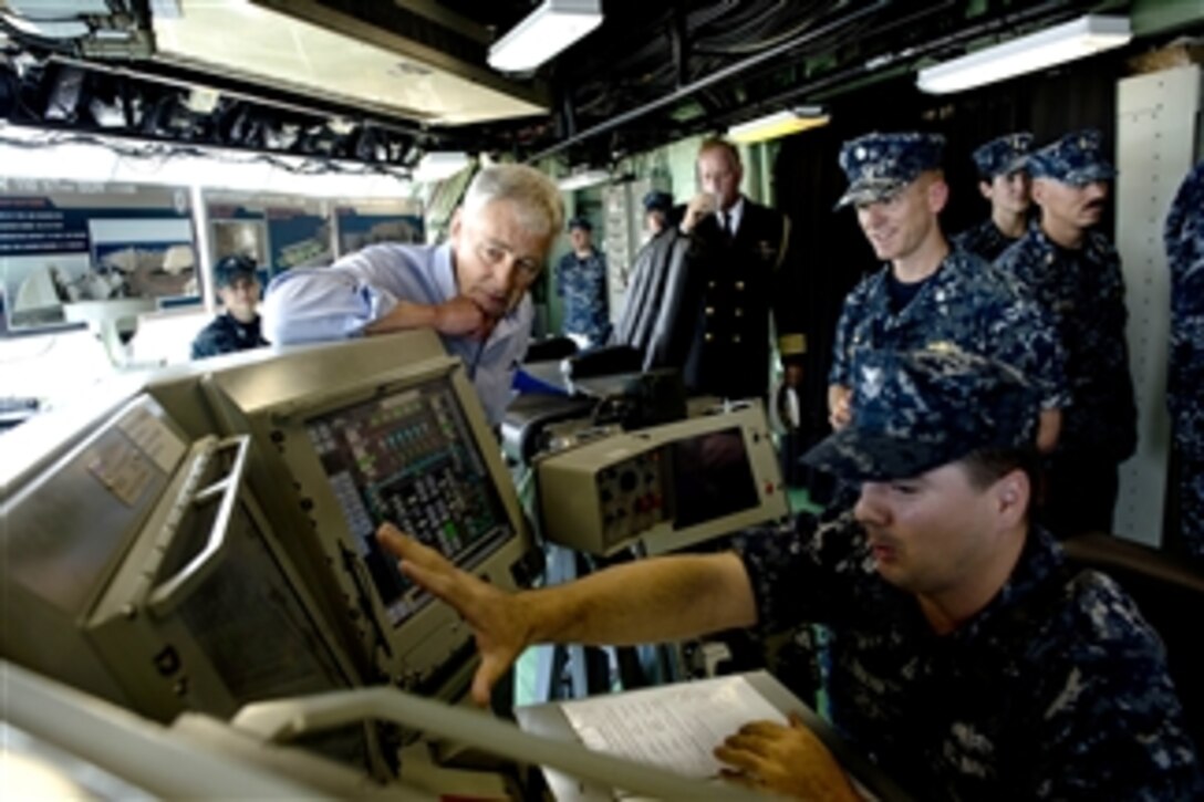 Secretary of Defense Chuck Hagel, left, listens to a sailor explain some of the technology on the bridge of the USS Freedom (LCS 1) in Singapore on June 2, 2013.  Hagel is touring the ship to visit with the crew and to watch a demonstration of a reconfigurable and waterborne mission.  Freedom is the Navy’s first littoral combat ship and is forward deployed for operations out of Singapore.  