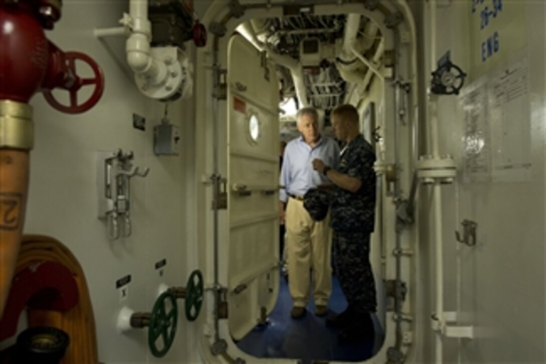 Secretary of Defense Chuck Hagel, left, listens to Navy Cmdr. Timothy Wilke as he tours the USS Freedom (LCS 1) in Singapore on June 2, 2013.  Hagel is touring the ship to visit with the crew and to watch a demonstration of a reconfigurable and waterborne mission.  Freedom is the Navy’s first littoral combat ship and is forward deployed for operations out of Singapore.  Wilke is the commanding officer of the USS Freedom.  