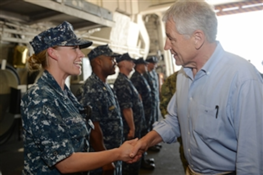 U.S. Navy Petty Officer 1st Class Rachel Preston, left, shakes hands with Secretary of Defense Chuck Hagel as he tours the USS Freedom (LCS 1) in Singapore on June 2, 2013.  Hagel is touring the ship to visit with the crew and to watch a demonstration of a reconfigurable and waterborne mission.  Freedom is the Navy’s first littoral combat ship and is forward deployed for operations out of Singapore.  