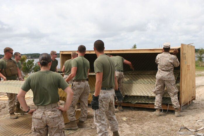 Service members from II Marine Expeditionary Force load matting back into a crate at the conclusion of a Marine Prepositioning Force Exercise aboard Marine Corps Support Facility Blount Island, Fla., May 29, 2013. The exercise was a way for Marines and sailors to learn more about MPF, and to prepare for a larger event scheduled to take place next year. (U.S. Marine Corps photo by Lance Cpl. Shawn Valosin)