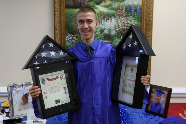 Steven C. James, a Nashville, N.C., native poses with two flags given to him from 2nd Marine Logistics Group, after a Christian Home School Association graduation in Rocky Mount, N.C., June 1, 2013. James is unable to enlist in the Marine Corps due to five open heart surgeries but received many tokens, challenge coins and gifts from the service members in support of his love of country and Marine Corps.