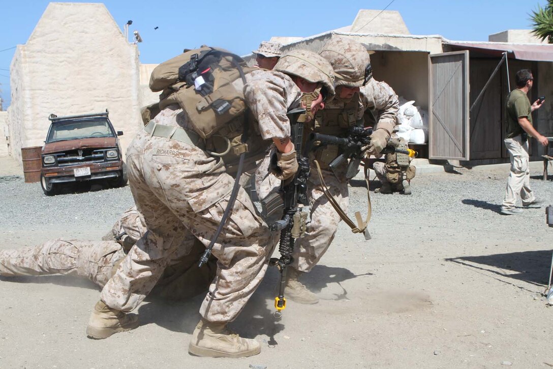 Lance Cpl. Josh Poynter (left), an assault man serving with Fox Company, 2nd Battalion, 1st Marine Regiment, and Cpl. Travis Richardson, a squad leader serving with Fox Co. drag a Marine out of a simulated firefight during Military Operations on Urban Terrain training at the Infantry Immersion Trainer here, May 29, 2013. Richardson, 24, from Surprise, Ariz., and Poynter, 28, from Indianapolis, Ind., moved their wounded comrade in to the cover of a building and began treating his simulated gunshot wound.