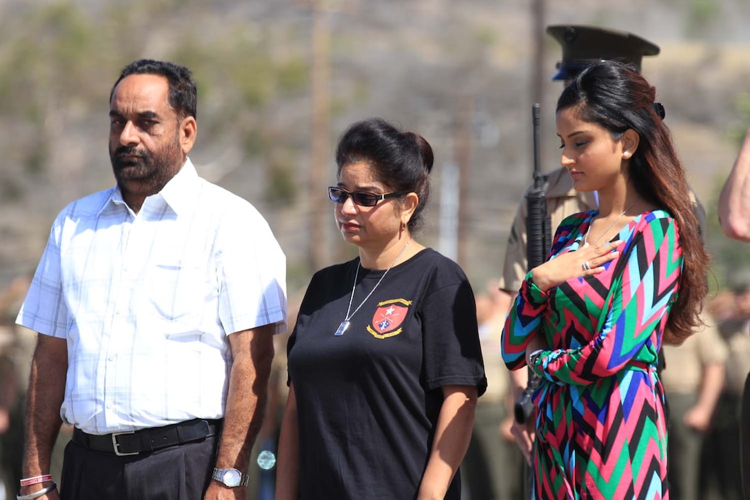 The family of Cpl. Gurpreet Singh stands in silence as the National Anthem plays during an award ceremony here, May 30, 2013. Singh, a native of Punjab, India, was awarded the Bronze Star with Combat "V" for valor posthumously for heroic service in Afghanistan. After immigrating to Sacramento, Calif., when he was 10, Singh enlisted as a rifleman in the Marine Corps when he turned 17, and went on to serve two combat deployments with Bravo Company, 1st Battalion, 5th Marine Regiment. As stated in his award citation, Singh aggressively led his Marines on daily combat patrols through insurgent infested areas in Sangin district, Helmand province, Afghanistan. Despite being struck in his front body armor by small-arms fire during a firefight on June 4, 2011, he remained undeterred and continued to lead his Marines. On June 22, 2011, while leading his Marines through a dangerous area, Singh was struck down by enemy fire.