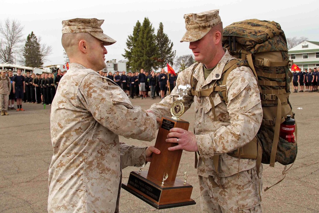 Recruiting Station Twin Cities' Maj. Kenneth Gawronski presents Recruiting Substation Mankato's Staff Sgt. Jason Hefner with the mini boot camp championship trophy for best office April 28. More than 650 aspiring Marines and guests attended the event. For additional imagery from the event, visit www.facebook.com/rstwincities. 