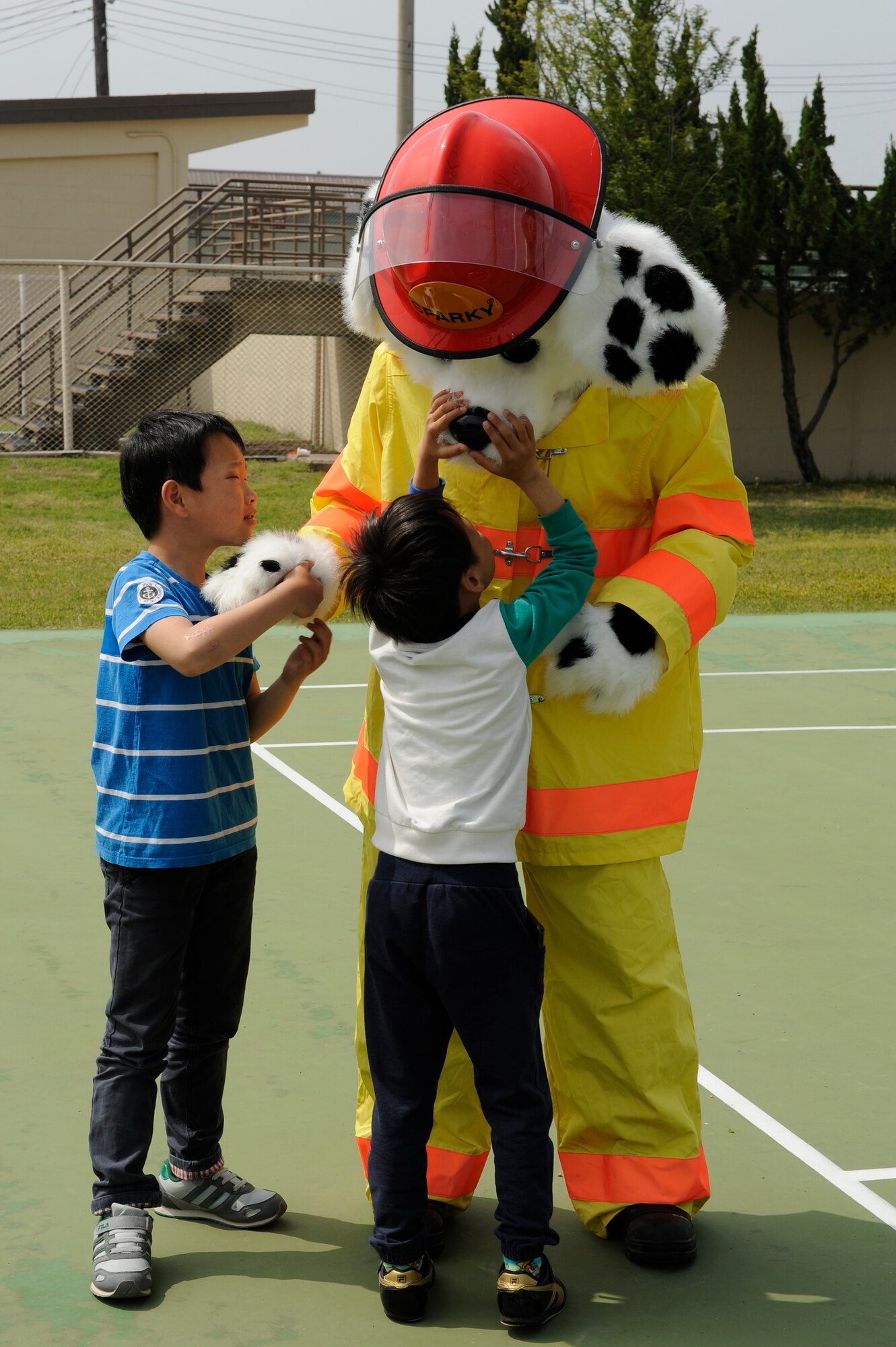 Children from Ilmagwon Orphanage, Gunsan City, Republic of Korea examine Sparky, 8th Civil Engineer Squadron firefighter mascot, during sports day at Kunsan Air Base, Republic of Korea, May 11, 2013. The children had the opportunity to climb the 8th CES fire truck’s ladder, pull a fire hose and wore firefighter gear. (U.S. Air Force photo by Senior Airman Marcus Morris/Released)