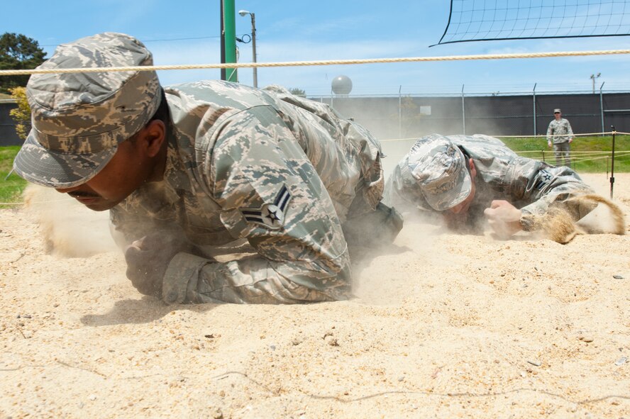 Airman 1st Classes Raymond Washington, front, and Alejandro Cuarenta, 8th Security Forces Squadron Bravo flight members, low crawl during a special defenders’ challenge at Kunsan Air Base, Republic of Korea, May 17, 2013. Bravo flight competed against other 8th SFS flights through six different events and finished with a time of 42:53. (U.S. Air Force photo by Staff Sgt. Jonathan Fowler/Released)