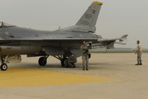 Airmen from the 8th Aircraft Maintenance Squadron conduct a final check on an F-16 Fighting Falcon during a large formation exercise at Kunsan Air Base, Republic of Korea, May 31, 2013. More than 30 F-16 Fighting Falcon pilots participated in the exercise, which featured numerous scenarios designed to test and hone their skills and abilities. (U.S. Air Force photo by Senior Airman Marcus Morris/Released)