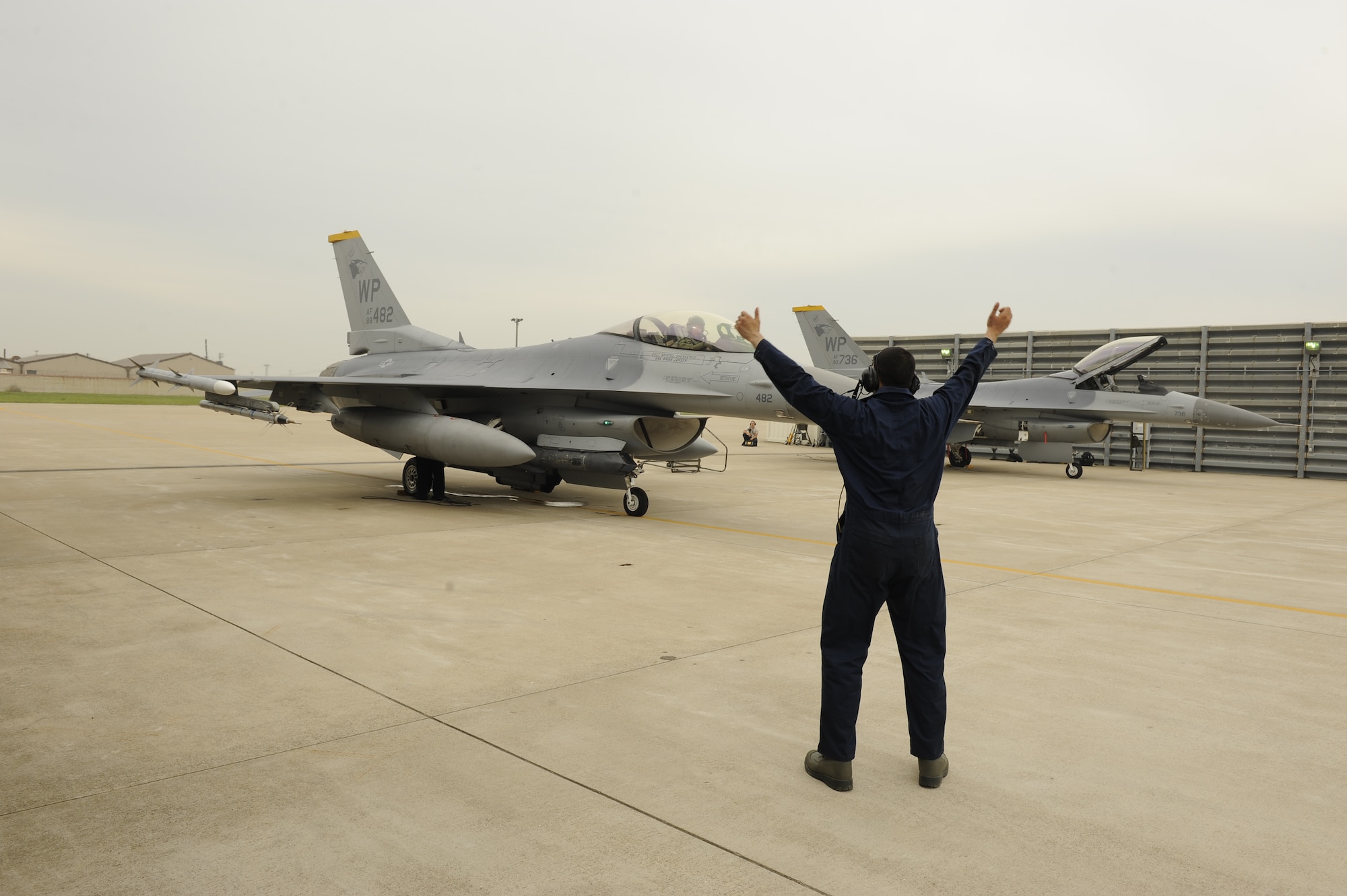 Senior Airman Cristian Jaramillo, 8th Aircraft Maintenance Squadron, guides Col. James Sturgeon, 8th Operations Group commander, into position at Kunsan Air Base, Republic of Korea, May 31, 2013. The large formation exercise was between the 35th Fighter Squadron, the 80th FS and the ROK air force, 38th Fighter Group. (U.S. Air Force photo by Senior Airman Marcus Morris/Released)