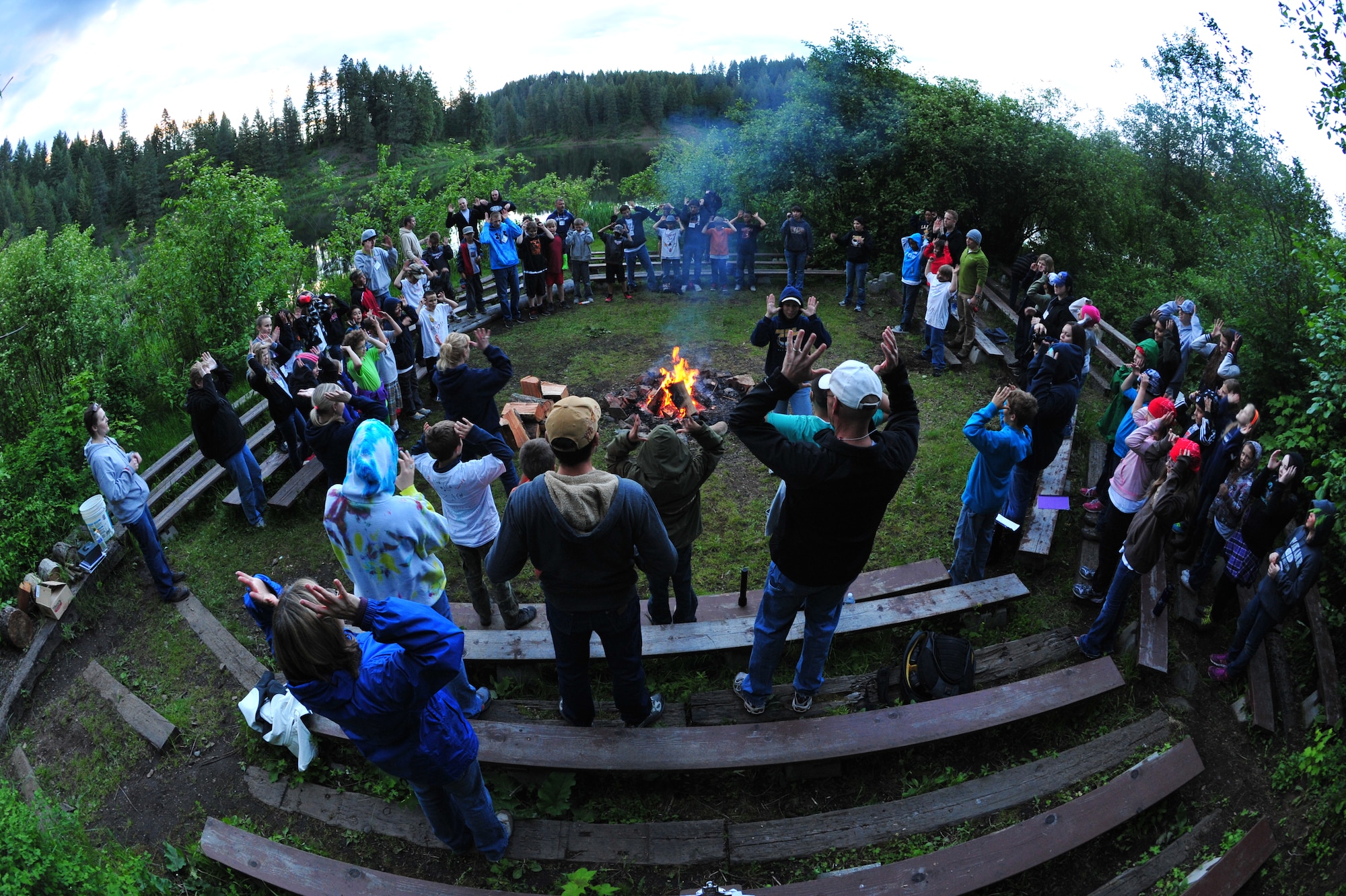Michael Anderson Elementary School fourth graders along with teachers and camp counselors gather around a camp fire while singing campfire songs May 30, 2013, at YMCA Camp Reed, which is located just 30 miles north of Spokane, Wash. The overnight camping trip, held for fourth grade students, took place May 30 through May 31. This trip has been a school tradition for more than 30 years. (U.S. Air Force photo by Senior Airman Earlandez Young/Released)