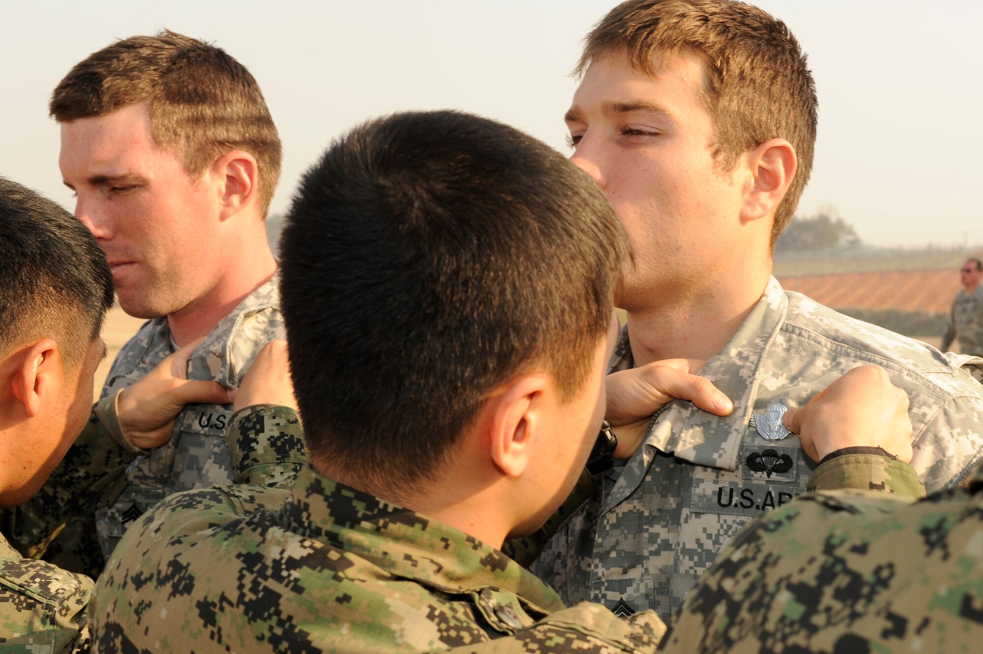 Soldiers from the Republic of Korea army 7th Special Forces Brigade, 35th Special Forces Battalion tack on the ROK jump pin onto their U.S. Army 3rd Battalion, 1st Special Forces Group counterparts after their training mission near Iksan, Republic of Korea, April 4, 2013. The two groups exchanged jump pins as a sign of friendship. (U.S. Air Force photo by Senior Airman Marcus Morris/Released)