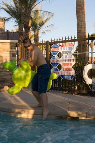 Senior Airman Matthew Lancaster, 99th Air Base Wing Public Affairs photojournalist, tests the water at the pool before going for a swim May 25, 2013, at Nellis Air Force Base, Nev. Every day, about ten people die from accidental drowning. Of these, two are children aged 14 or younger. Drowning ranks fifth among the leading causes of unintentional injury death in the United States. (U.S. Air Force photo by Airman 1st Class Christopher Tam)