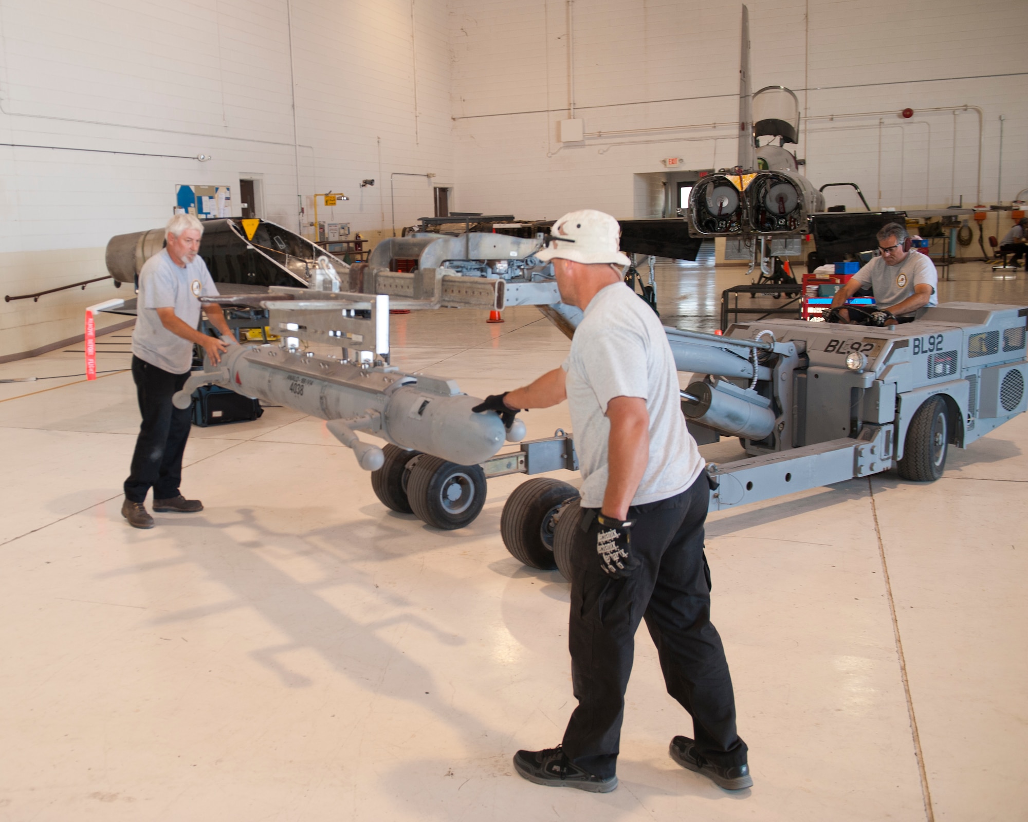 Ronald Legand, and Jeremy Hale, both M1 Support Services maintainers, prepare to load a radar jammer pod onto a T-38 Talon at Holloman Air Force Base, N.M., Jun 4. For the first time, the T-38 has been modified to fit the ALQ-188 pod for use as a radar jammer. This newest addition to the T-38 will assist in its training mission by making it a more effective adversary for the F-22 Raptor during simulated combat exercises. (U.S. Air Force photo by Airman 1st Class Daniel E. Liddicoet/Released)
