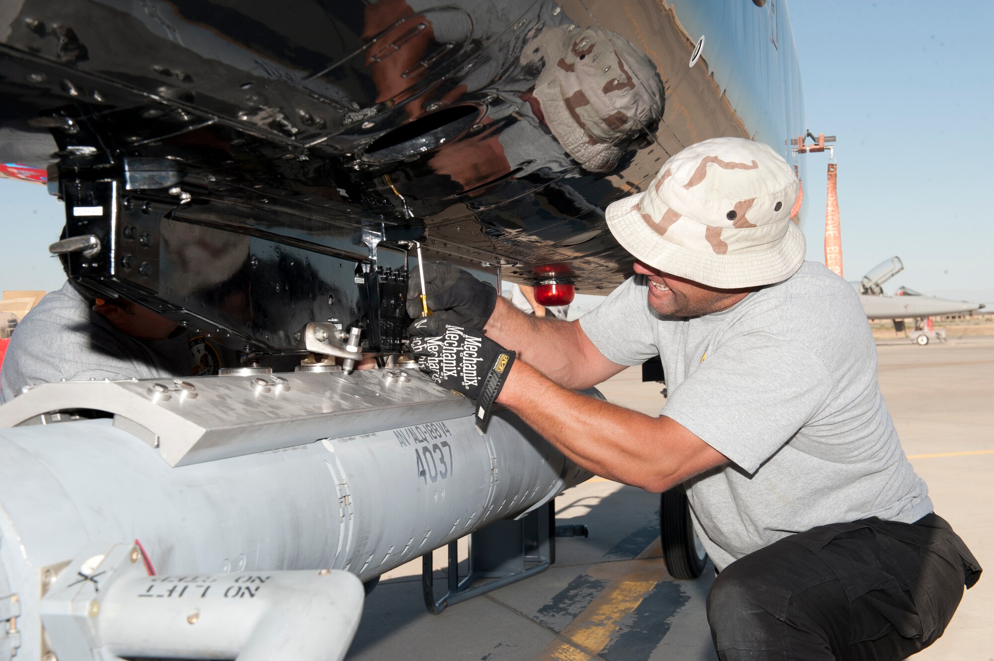 Jeremy Hale, M1 Support Services maintainer, attaches a radar jammer pod onto a T-38 Talon at Holloman Air Force Base, N.M., Jun 4. For the first time, the T-38 has been modified to fit the ALQ-188 pod for use as a radar jammer. This newest addition to the T-38 will assist in its training mission by making it a more effective adversary for the F-22 Raptor during simulated combat exercises. (U.S. Air Force photo by Airman 1st Class Daniel E. Liddicoet/Released)