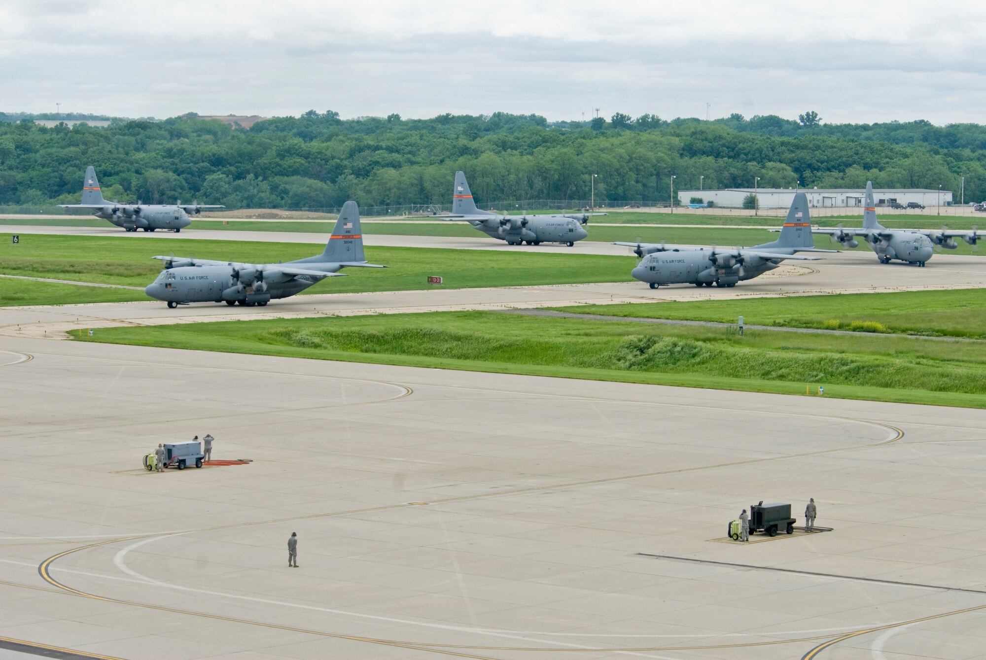 Illinois Air National Guard C-130H3 Hercules aircraft enter the 182nd Airlift Wing apron in Peoria, Ill., June 2, 2013.  The military transport planes participated in a rare seven-ship taxi in which seven aircraft from the Air National Guard base flew together simultaneously in formation.  (U.S. Air National Guard photo by Staff Sgt. Lealan Buehrer/Released)