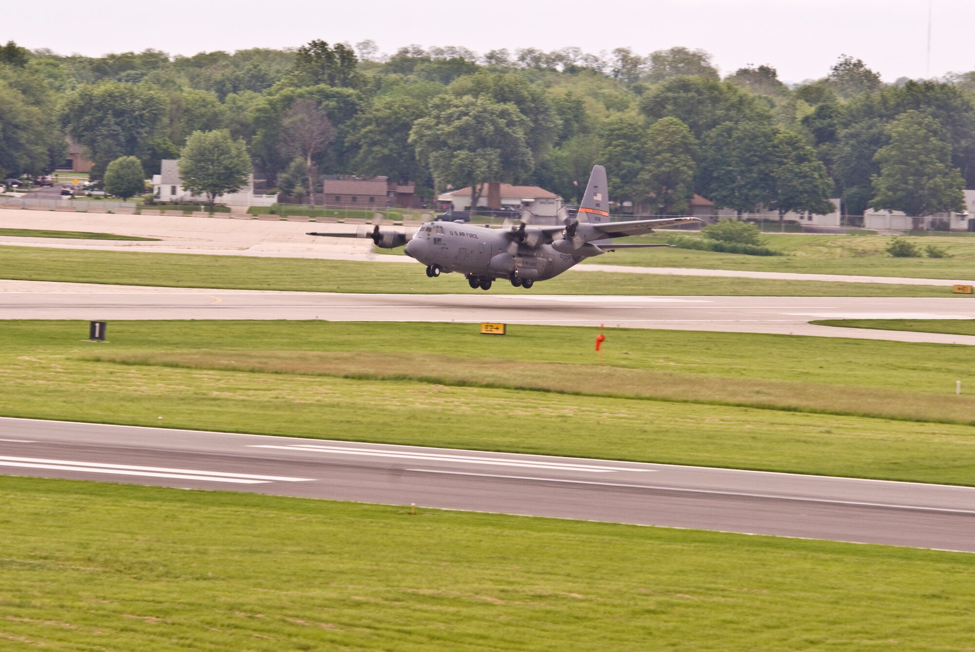An Illinois Air National Guard C-130H3 Hercules aircraft touches down on a runway at the 182nd Airlift Wing in Peoria, Ill., June 2, 2013.  The military transport plane participated in a rare seven-ship taxi in which seven aircraft from the Air National Guard base flew together simultaneously in formation.  (U.S. Air National Guard photo by Staff Sgt. Lealan Buehrer/Released)