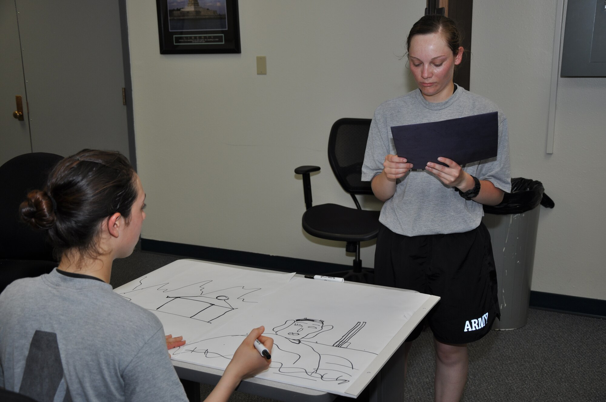 GOODFELLOW AIR FORCE BASE, Texas – Army Spc. Ximena Fonseca, Army 344th Military Intelligence Battalion student, draws the image Army Spc. Kristy Hanson, Army 344th MIB student, describes for the Draw Me portion of the 316th Training Squadron Language Competition inside the 315th Training Squadron, May 24. Fonseca and Hanson were part of the Spanish language team, which was one of six teams who competed in the event. (U.S. Air Force photo/ Airman 1st Class Joshua Edwards)