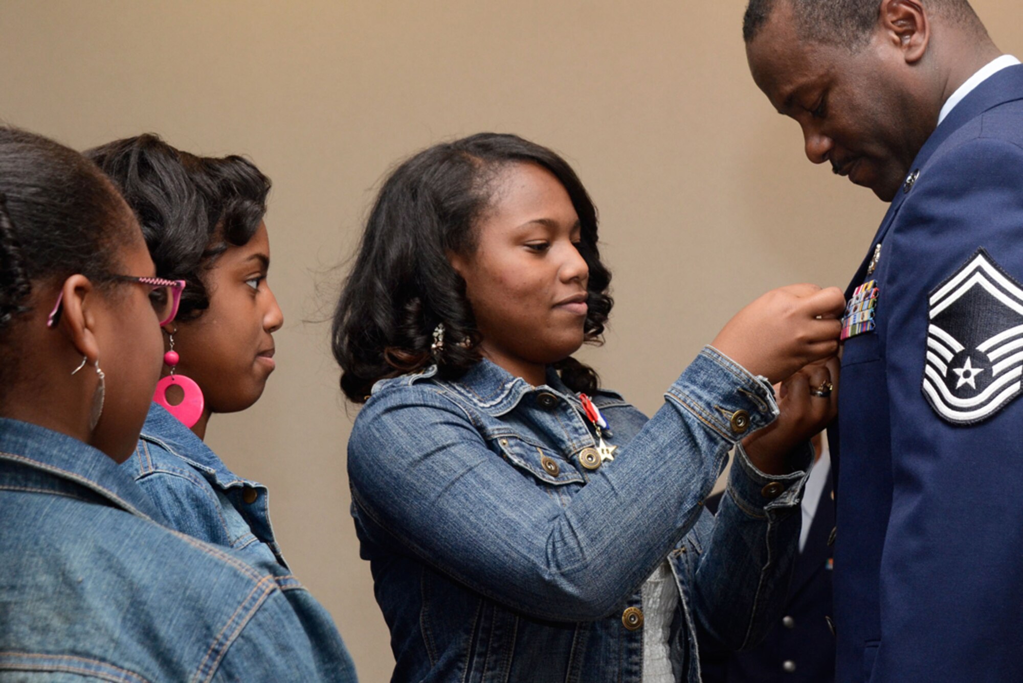 Daughters Kayla, Anitia, and Diamante’ Smith pin the retirement pin on Senior Master Sgt. Sheldon D. Smith, 94th Civil Engineering Squadron engineering flight superintendent, during his retirement ceremony May 12. (U.S. Air Force photo/Don Peek)
