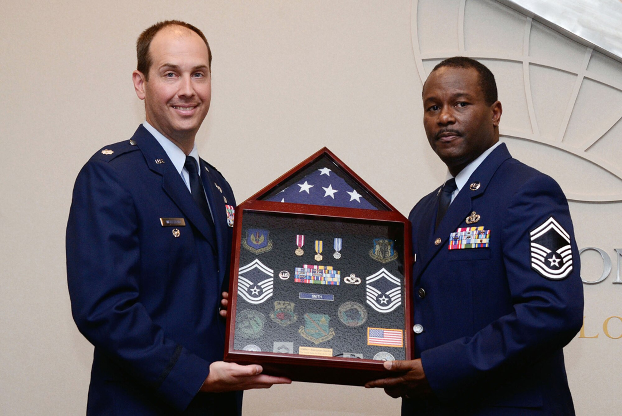 Lt. Col. Christopher T. Whitehead, 94th Mission Support vice commander, presents Senior Master Sgt. Sheldon D. Smith, 94th Civil Engineering Squdron engineering flight superintendent, with a traditional shadow box highlighting his 31 year career during his retirement ceremony May 12. (U.S. Air Force photo/Don Peek)