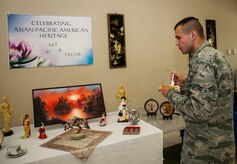 Airman 1st Class Charles Hudson, 628th Medical Group medical logistics technician, samples  Asian themed food as he explores  the decorations during the Asian Pacific Heritage Month luncheon May 30, 2013, at the Chapel Annex at Joint Base Charleston – Air Base, S.C. The luncheon included Asian themed food, drinks, candy, decorations and items for service members and their families to enjoy. (U.S. Air Force photo/ Senior Airman Dennis Sloan)