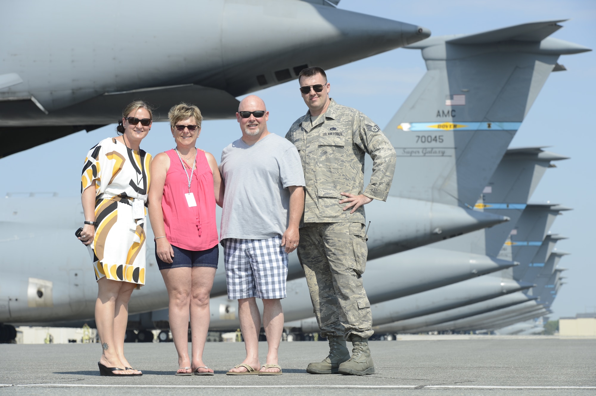 Mr. Todd Bodine and Mrs. Janet Bodine (center) of ThorSport Racing pose with Mrs. Jen Vallee (left), 436th Airlift Wing/Public Affairs chief of community relations, and Staff Sgt. Tyler Spencer in front a line of C-5M Super Galaxy aircraft during a visit to Dover Air Force Base, Del., on May 30, 2013. Todd Bodine raced at Dover International Speedway last weekend in the NASCAR Camping World Truck Series Race Lucas Oil 200. (U.S. Air Force photo/Greg L. Davis)