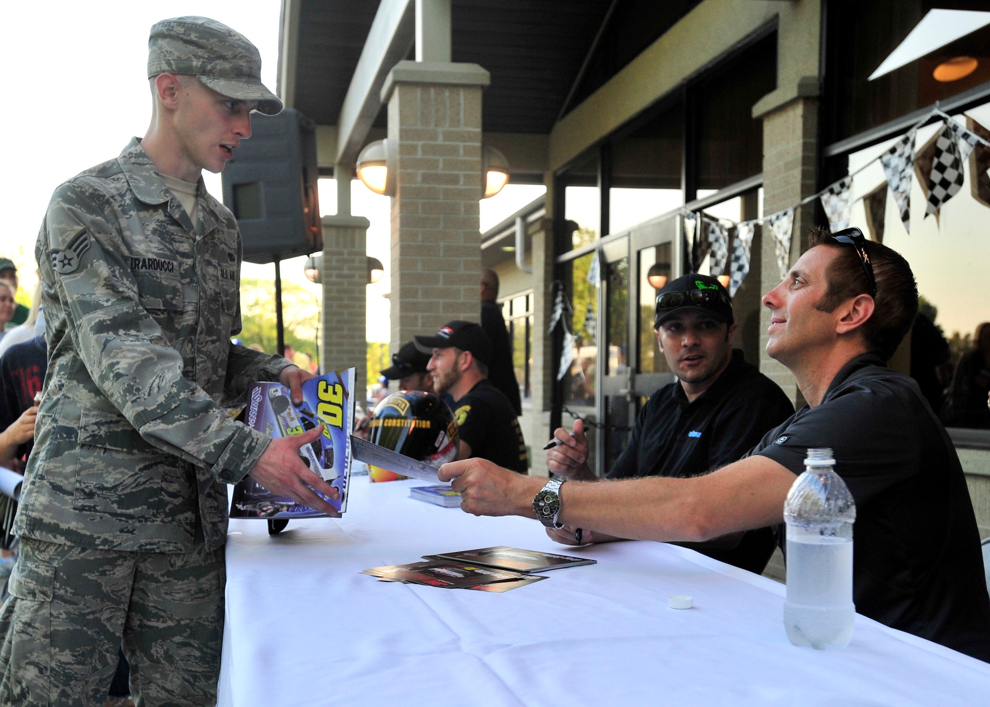 Senior Airman Jordon Berarducci, 436th Aircraft Maintenance Squadron, gets an autograph from NASCAR Sprint Cup Series driver Greg Biffle during the NASCAR Meet and Greet May 31, 2013, at Mulligans on Dover Air Force Base, Del. Berarducci and other Team Dover members had the opportunity to get autographs and have their picture taken with drivers. (U.S. Air Force photo/Tech. Sgt. Chuck Walker)