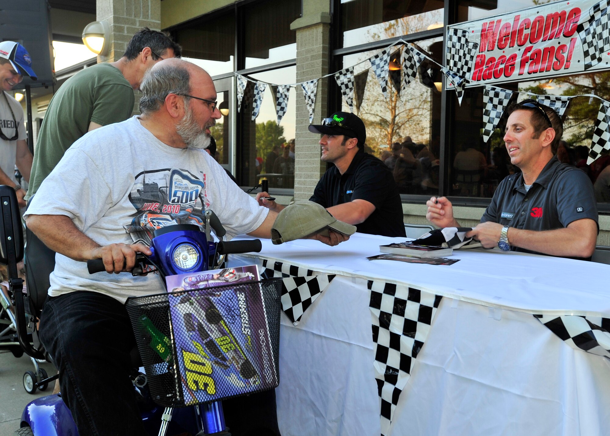 A race fan gets his hat autographed by NASCAR Sprint Cup Series driver Greg Biffle during the NASCAR Meet and Greet May 31, 2013, at Mulligans on Dover Air Force Base, Del. The Meet and Greet gave Team Dover members a chance to meet drivers. (U.S. Air Force photo/Tech. Sgt. Chuck Walker)