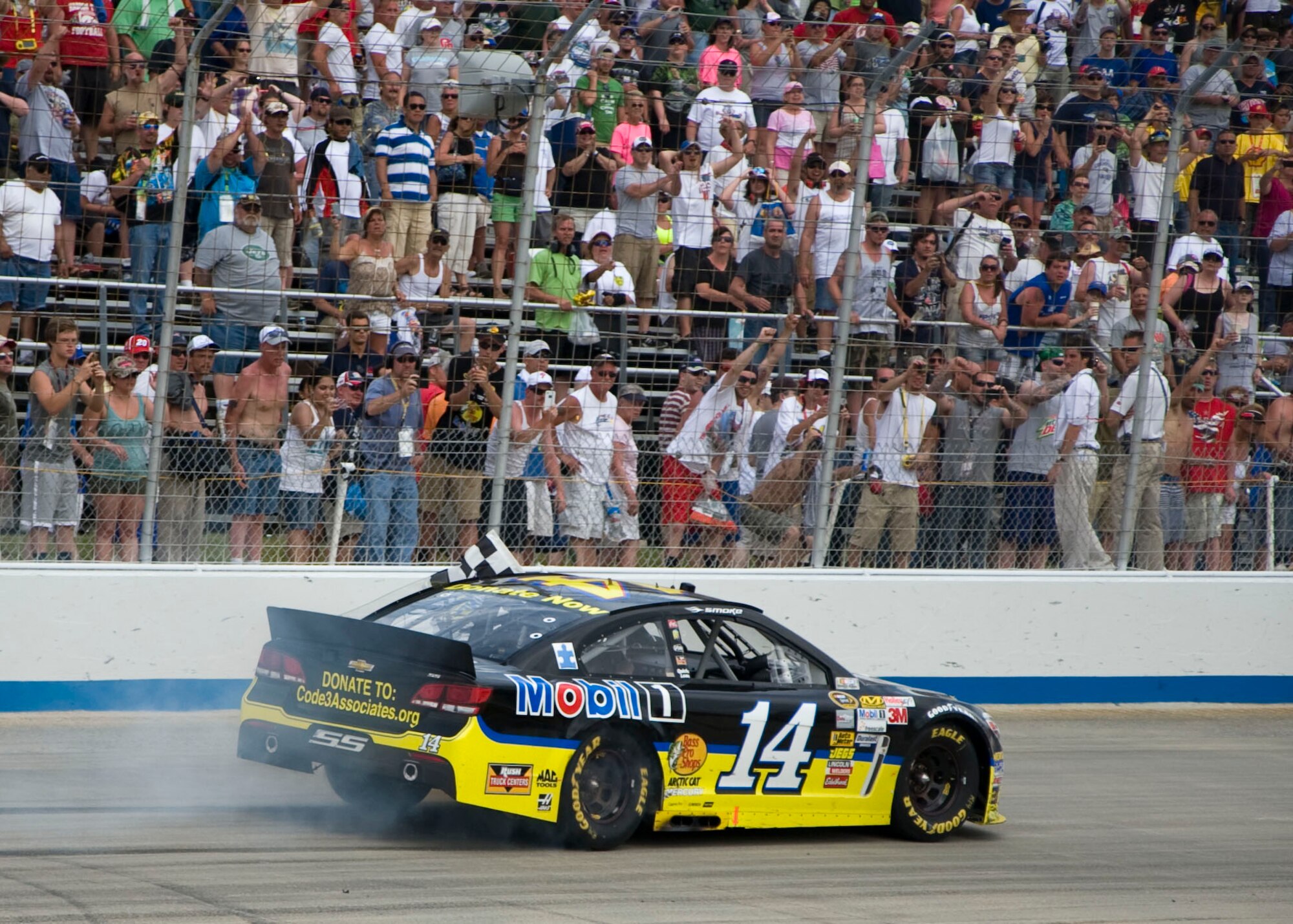 Tony Stewart, driver of the No. 14 Mobil One Chevy, celebrates in front of the fans following his victory in the Fed Ex 400 Benefiting Autism Speaks June 2, 2013, at Dover International Speedway in Dover, Del. Stewart ended a 30-race win drought with his victory at the Monster Mile. (U.S. Air Force photo/Senior Airman Jared Duhon)