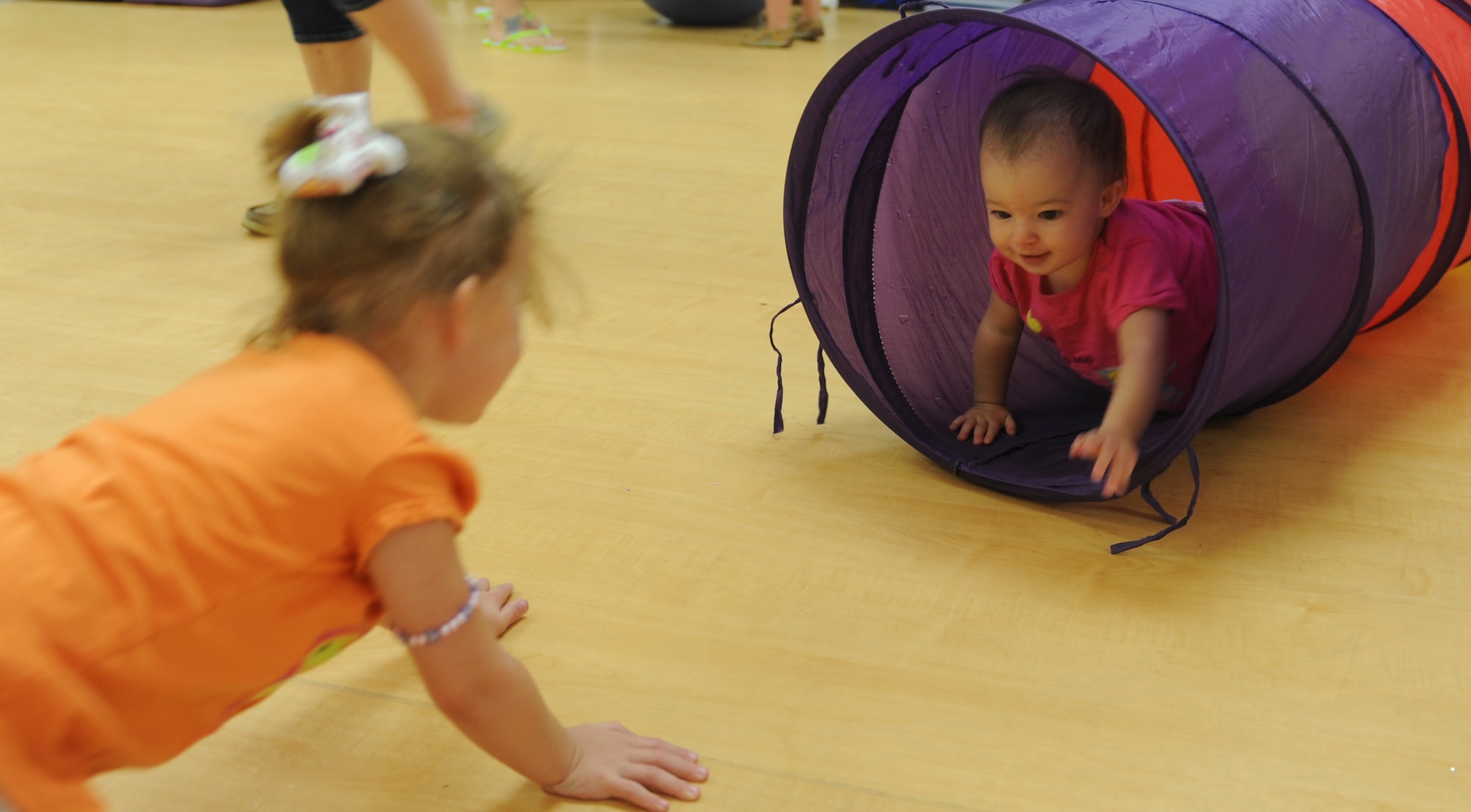 Lilly, daughter of Staff Sgt. Henry Bradshaw 23d Aircraft Maintenance Squadron avionics systems craftsman, plays with her older sister Chloee at Moody Air Force Base, Ga., May 31, 2013. The sisters interacted with children ranging in age from 6 months to 4 years old at the Moody Family Connections Playgroup. (U.S. Air Force photo by Airman Alexis Grotz/Released)