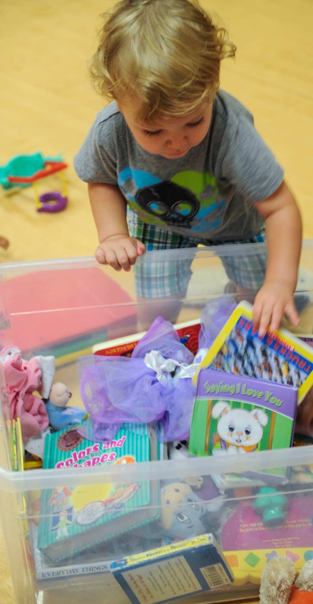 Dominic, son of Tech. Sgt. Eric Ybarra, 23d Equipment Maintenance Squadron production supervisor for conventional maintenance, chooses a book from a box of toys at Moody Air Force Base, Ga., May 31, 2013. Moody Family Connections Playgroup, formerly known as Tator tots, places toys so children can play together. (U.S. Air Force photo by Airman Alexis Grotz/Released)