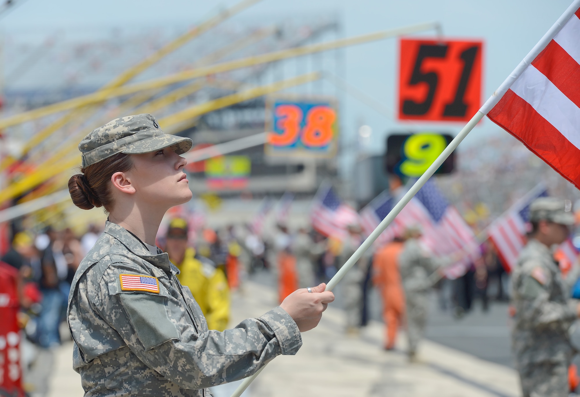 Private 1st Class Jessica Reed, of C Company, 198th Rear Detachment Batallion, Delaware Army National Guard, holds a U.S. Flag during pre-race ceremonies before the start of the Fed Ex 400 Benefiting Autism Speaks June 2, 2013, at Dover Air Force Base, Del. The military played a huge role in the success of the race. (U.S. Air Force photo/Greg L. Davis)