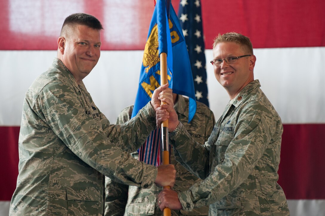 Col. James Katrenak, 28th Maintenance Group commander (left), presents the guidon for the 28th Maintenance Squadron to the new 28th MXS commander, Maj. Larry Rochat, during a ceremony on Ellsworth Air Force Base, S.D, June 3, 2013. Rochat was commander of the 28th Maintenance Operations Squadron, which was inactivated prior to the change of command. The personnel and assets are being realigned to optimize maintenance operations under the 28th MXG umbrella. (U.S. Air Force photo by Senior Airman Kate Maurer/Released) 