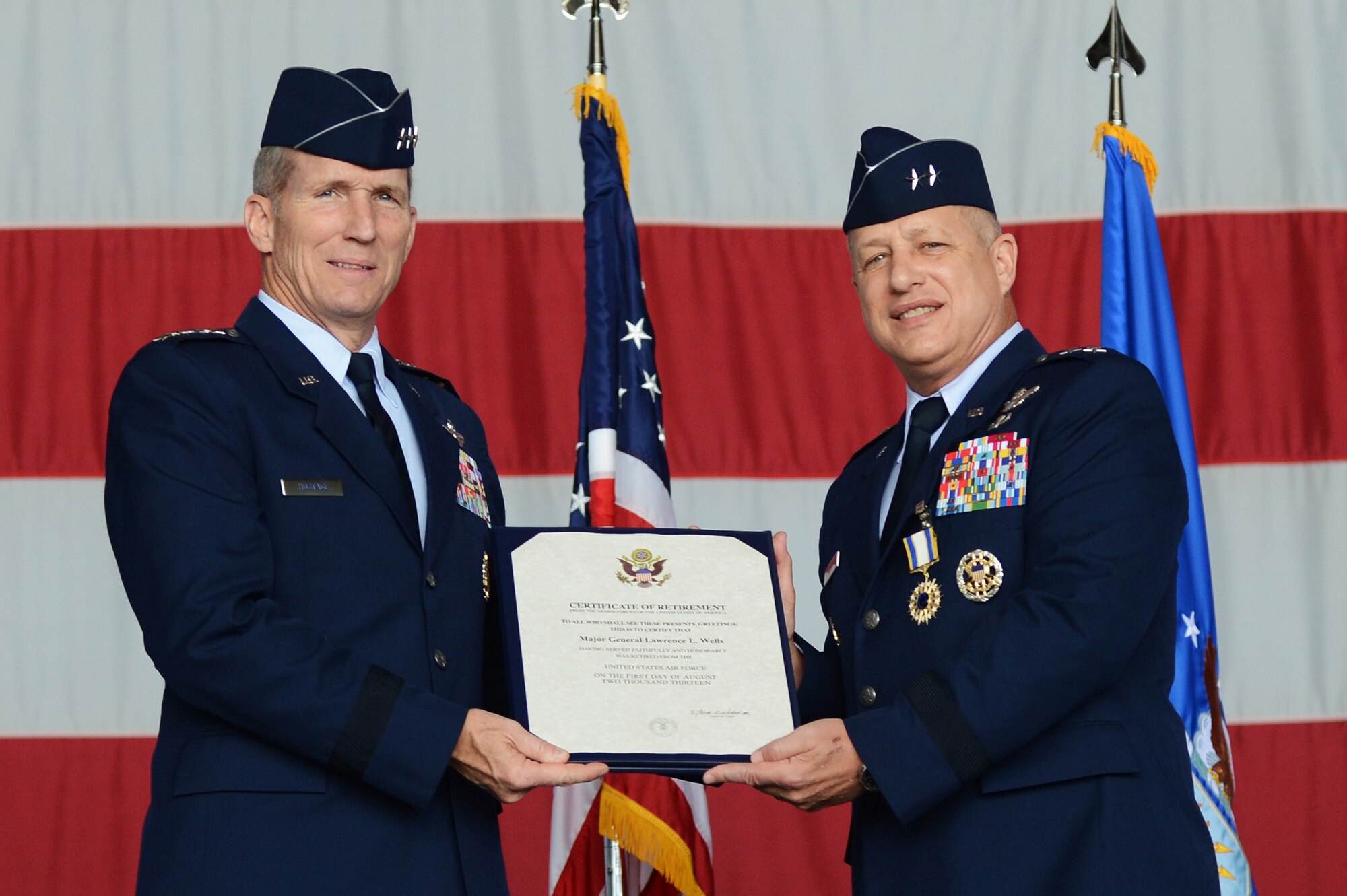 Gen. Mike Hostage, commander of Air Combat Command, presents Maj. Gen. Lawrence Wells, 9th Air Force commander, with his certificate of retirement after 35 years of service to the United States Air Forces, Shaw Air Force Base, S.C., May 31, 2013. Well’s retirement ceremony followed the 9th Air Force change of command ceremony where Maj. Gen. Jake Polumbo took command of 9th Air Force. (U.S. Air Force photo by Airman 1st Class Daniel Blackwell/Released)
