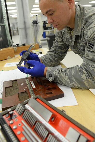 Airman 1st Class Anthony Edgar, 20th Component Maintenance Squadron technical maintenance data equipment technician, tests the accuracy of a digital micrometer by using precisely pre-measured gage blocks at Shaw Air Force Base, S.C., May 17, 2013. The micrometer measures anything that has diameter or length like landing gear pins, clamps and frames used to ensure landing capabilities of the F-16 Fighting Falcons.  (U.S. Air Force photo by Airman 1st Class Krystal M. Jeffers/Released)