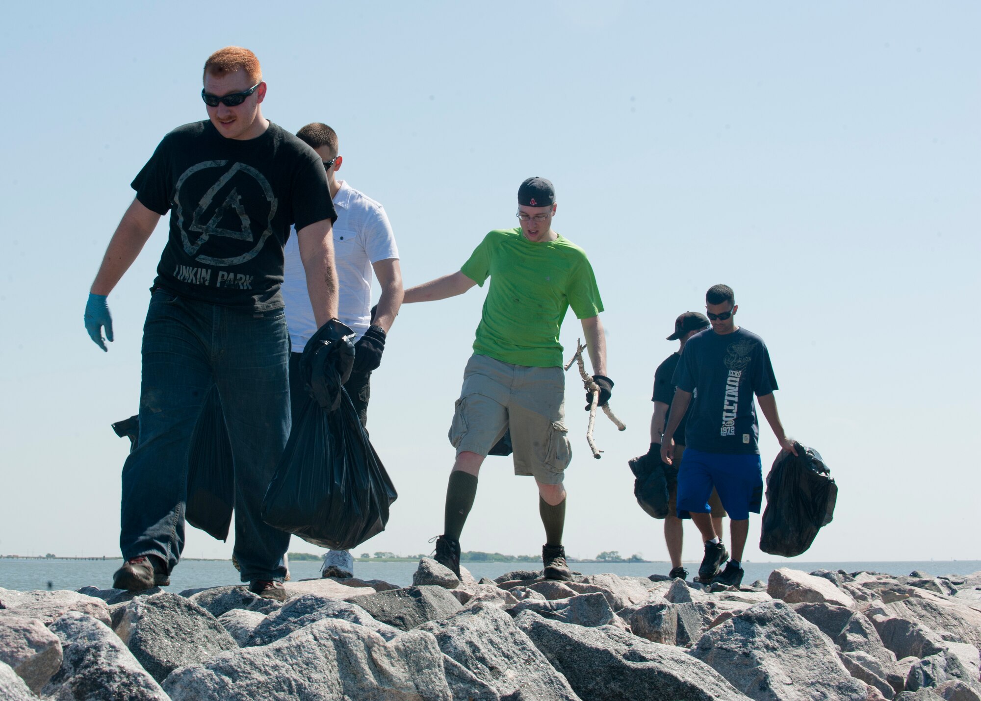 Langley Airmen search along the rocks for items that may be harmful to the environment and wildlife during Clean the Bay Day at Langley Air Force Base Va., June 1, 2013. Volunteers collected more than 3,000 pounds of trash during the three-hour clean-up. (U.S. Air Force photo by Airman 1st Class Kimberly Nagle/Released)