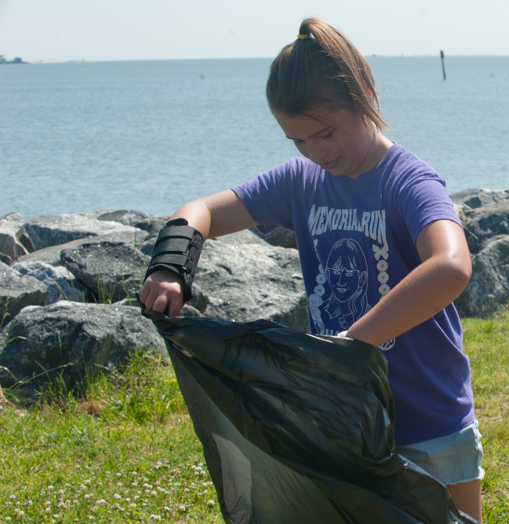 Kayley Torres, 10, helps collect trash with her siblings and mother, Staff Sgt. Elizabeth Torres, 633rd Air Base Wing Equal Opportunity Office EO specialist, during Clean the Bay Day at Langley Air Force Base, Va., June 1, 2013. Kayley was one of many military dependents participating. (U.S. Air Force photo by Airman 1st Class Kimberly Nagle/Released)