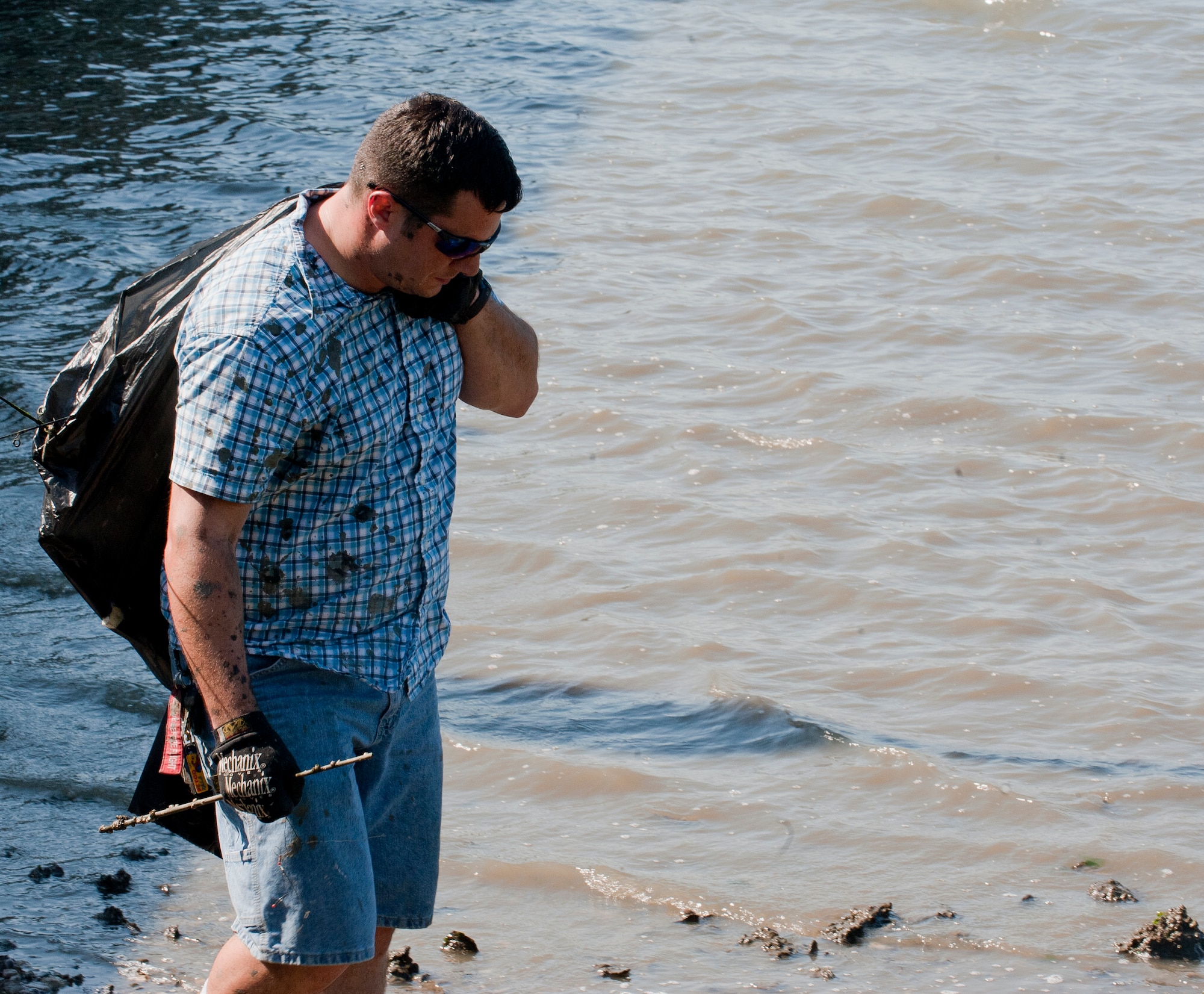 U.S. Air Force Master Sgt. Ted Winnen, Headquarters Air Combat Command Directorate of Maintenance and Logistics command system manager, scans the shoreline for debris during Clean the Bay Day at Langley Air Force Base, Va., June 1, 2013. The statewide event has been in place for 25 years. (U.S. Air Force photo by Airman 1st Class Kimberly Nagle/Released) 