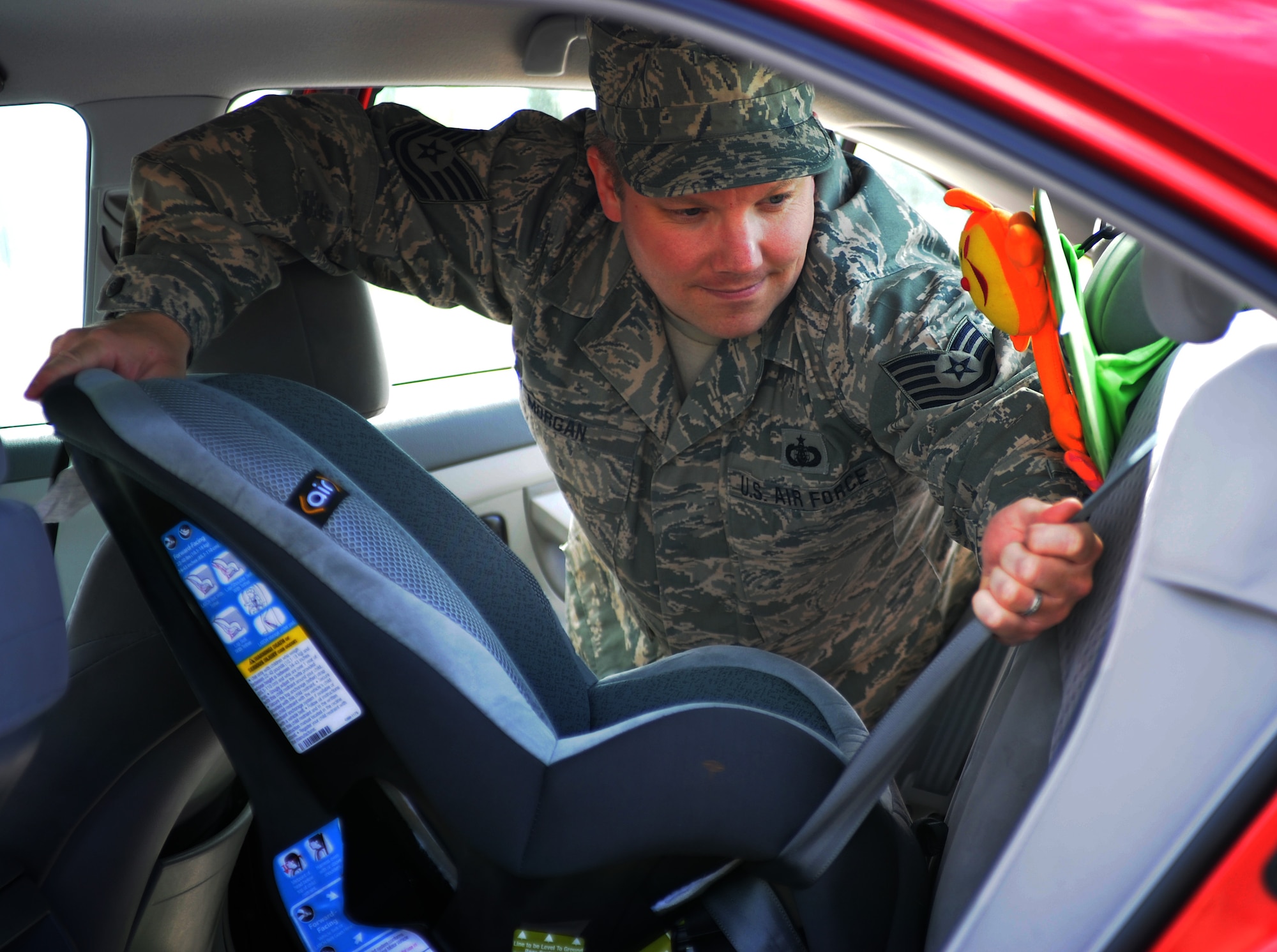 Tech. Sgt. Patrick Morgan, 141st Air Refueling Wing, eyes the handiwork of Safe Kids Spokane after they inspected his child’s car seat at the free car seat check-up at the Commissary parking lot at Fairchild Air Force Base, Wash., May 30, 2013. (U.S. Air Force photo by Airman 1st Class Sam Fogleman/Released) 