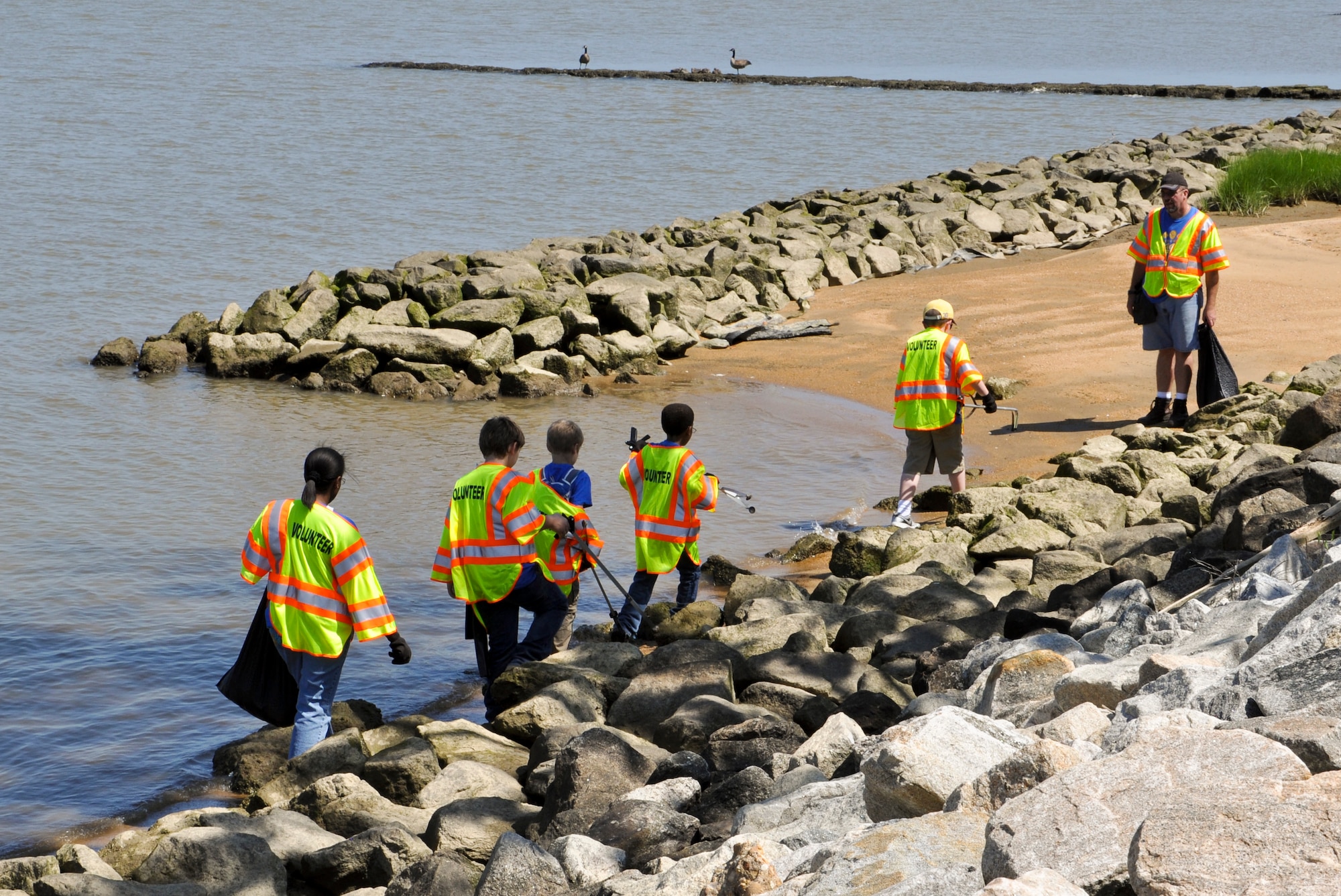Volunteers from Cub Scout Pack 143 navigate the shoreline to pick up trash during the 25th annual Clean the Bay Day along the shoreline at Fort Eustis, Va., June 1, 2013. An estimated 740 pounds of trash was collected from Fort Eustis. (U.S. Air Force photo by Tech Sgt. April Wickes/Released)