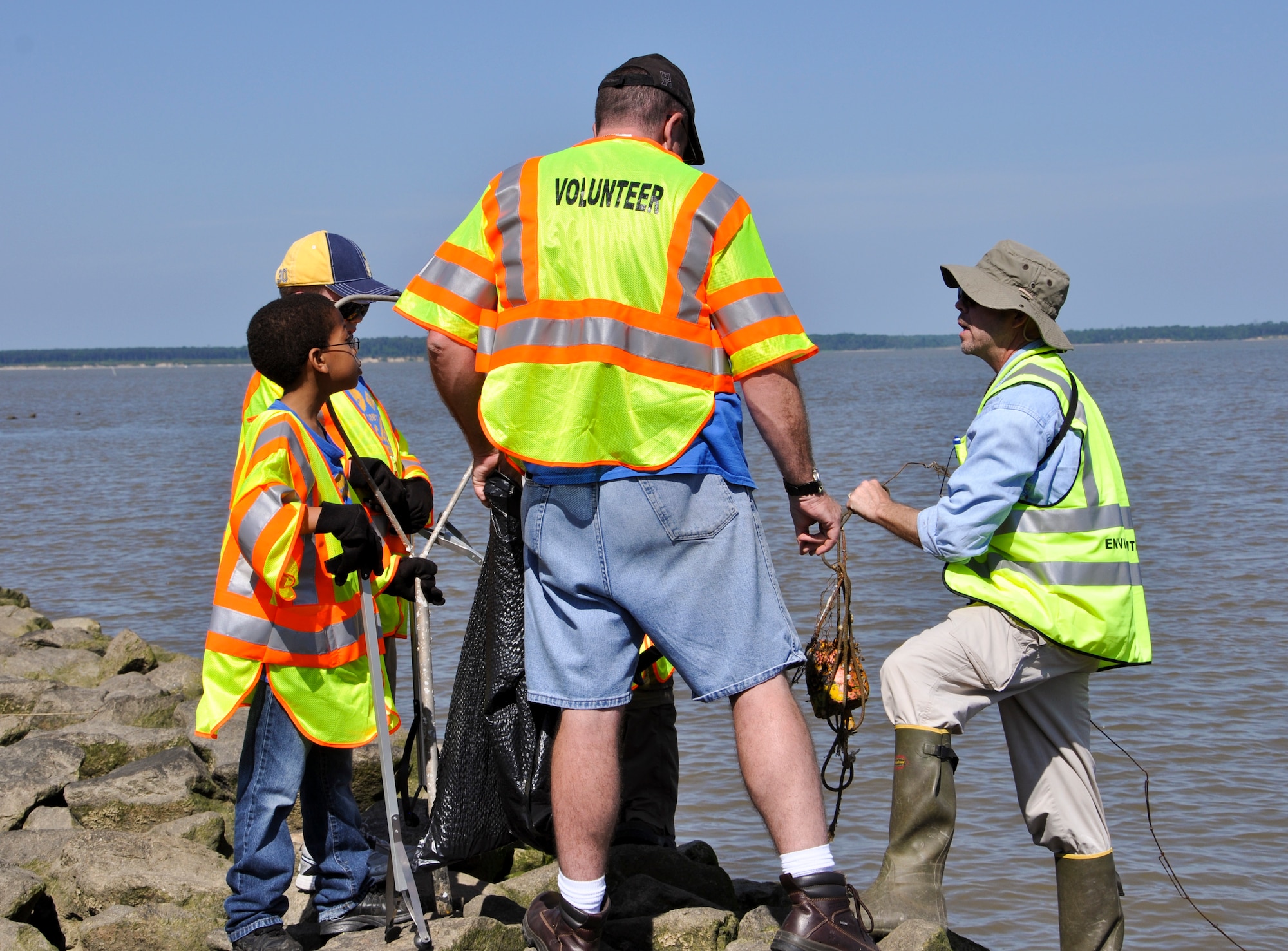 Timothy P. Christensen, 733rd Civil Engineer Division conservation branch chief (right) and volunteers from Cub Scout Pack 143, collect an old lobster trap during the 25th annual Clean the Bay Day along the shoreline at Fort Eustis, Va., June 1, 2013. Clean the Bay Day is a Virginia-wide effort to remove refuse and trash from shorelines. (U.S. Air Force photo by Tech Sgt. April Wickes/Released)