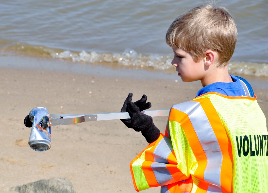 Jared Lawrence, 7, from Cub Scout Pack 143, picks up a soda can during the 25th annual Clean the Bay Day along the shoreline at Fort Eustis, Va., June 1, 2013.  Members of Cub Scout Pack 143, from Newport News, Va., have been participating in Clean the Bay Day for more than 20 years. (U.S. Air Force photo by Tech Sgt. April Wickes/Released)