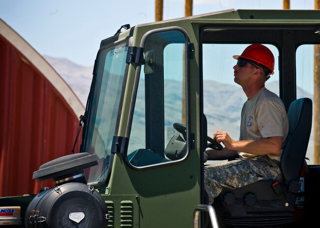 Staff Sgt. Leigh Barnard, 647th Quartermaster Company parachute rigger uses heavy machinery to lift cargo in preparation for a Joint Forcible Entry Exercise May 29, 2013, at Nellis Air Force Base, Nev. The exercise also tests the large-scale heavy equipment and troop movements of the United States Army and United States Air Force. (U.S. Air Force Photo by Airman 1st Class Jason Couillard)